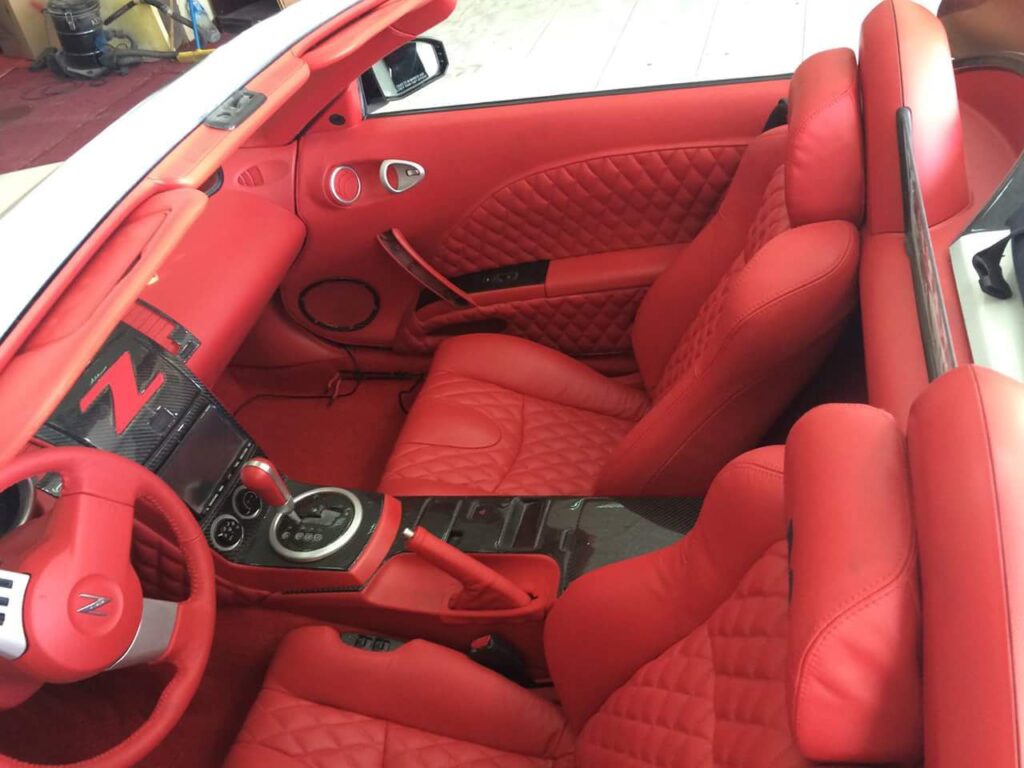 Interior view of a red sports car featuring luxurious leather seats and a sleek, modern design.