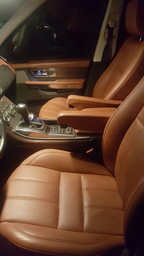 Interior view of a car featuring luxurious brown leather seats and elegant car upholstery details.