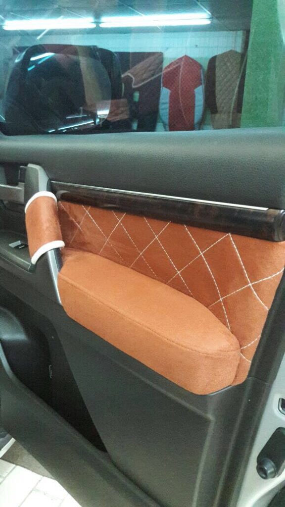 A car door panel featuring elegant brown and white trim, showcasing stylish car upholstery design elements.