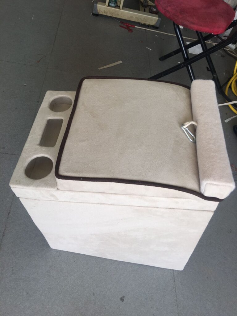 A small white box featuring a seat and cushion, designed as a component of car upholstery.