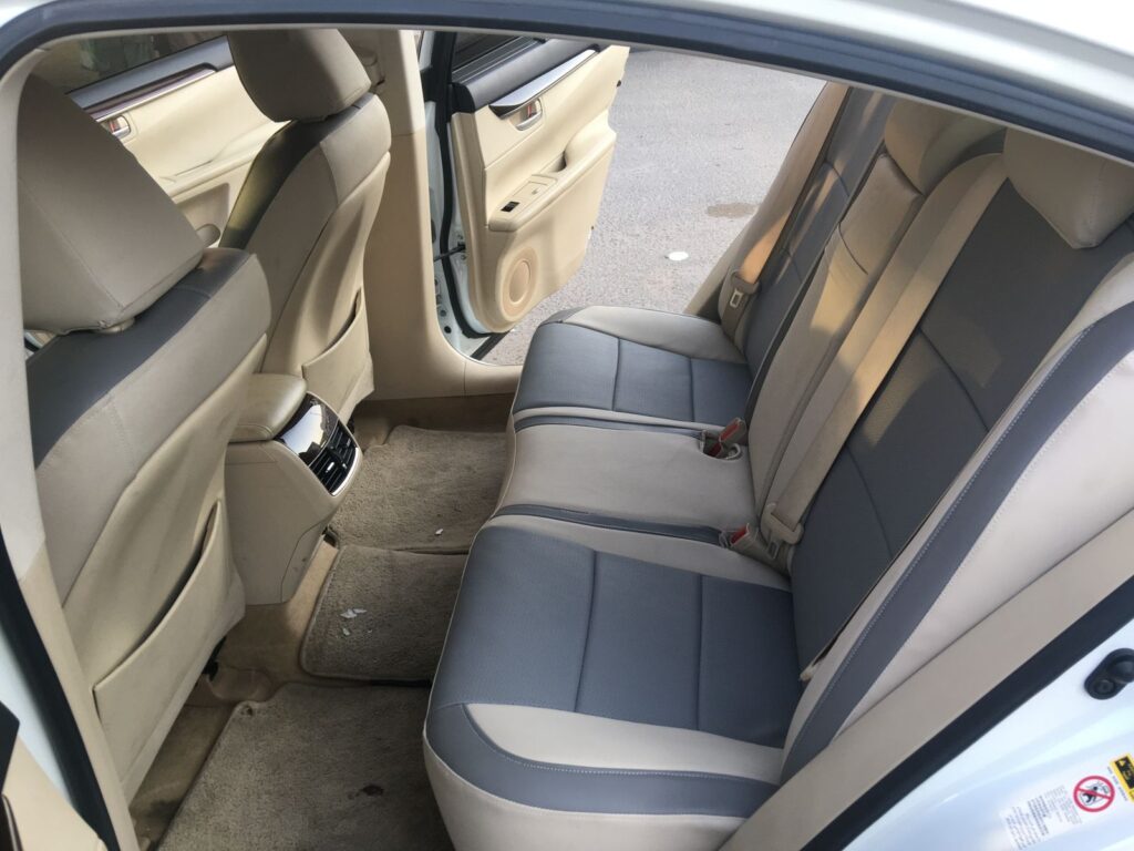 Empty back seats of a car showcasing clean upholstery and spacious interior, emphasizing a sense of openness and comfort.