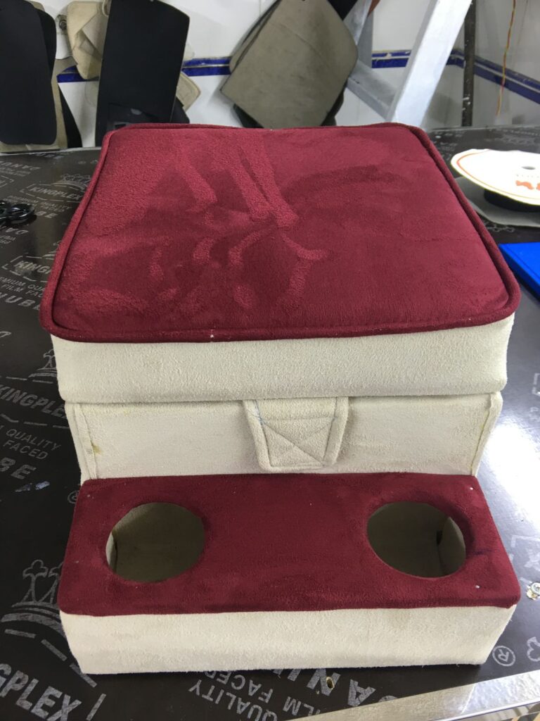 A red and white box designed for car upholstery, featuring two holes for installation or ventilation purposes.