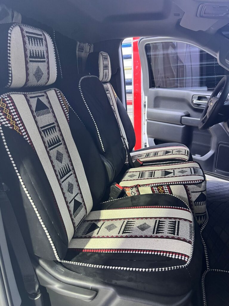 Seats in a car upholstered with a striking tribal design, highlighting unique patterns that enhance the interior aesthetic.