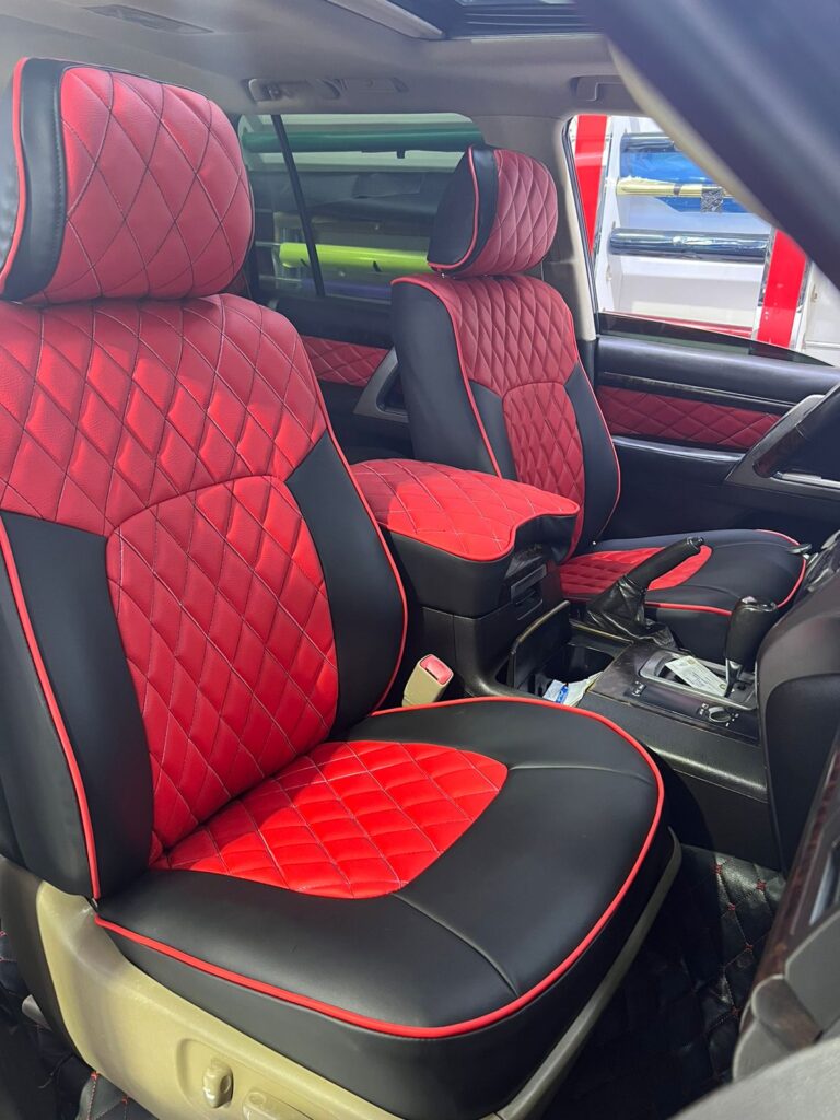 Premium red and black leather car seat with a quilted pattern, showcasing brand new upholstery from AlBadiiya.