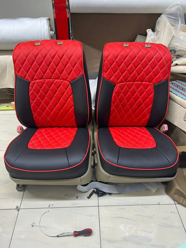 Two red and black leather car seats featuring a quilted pattern, showcasing a stylish and modern upholstery design.