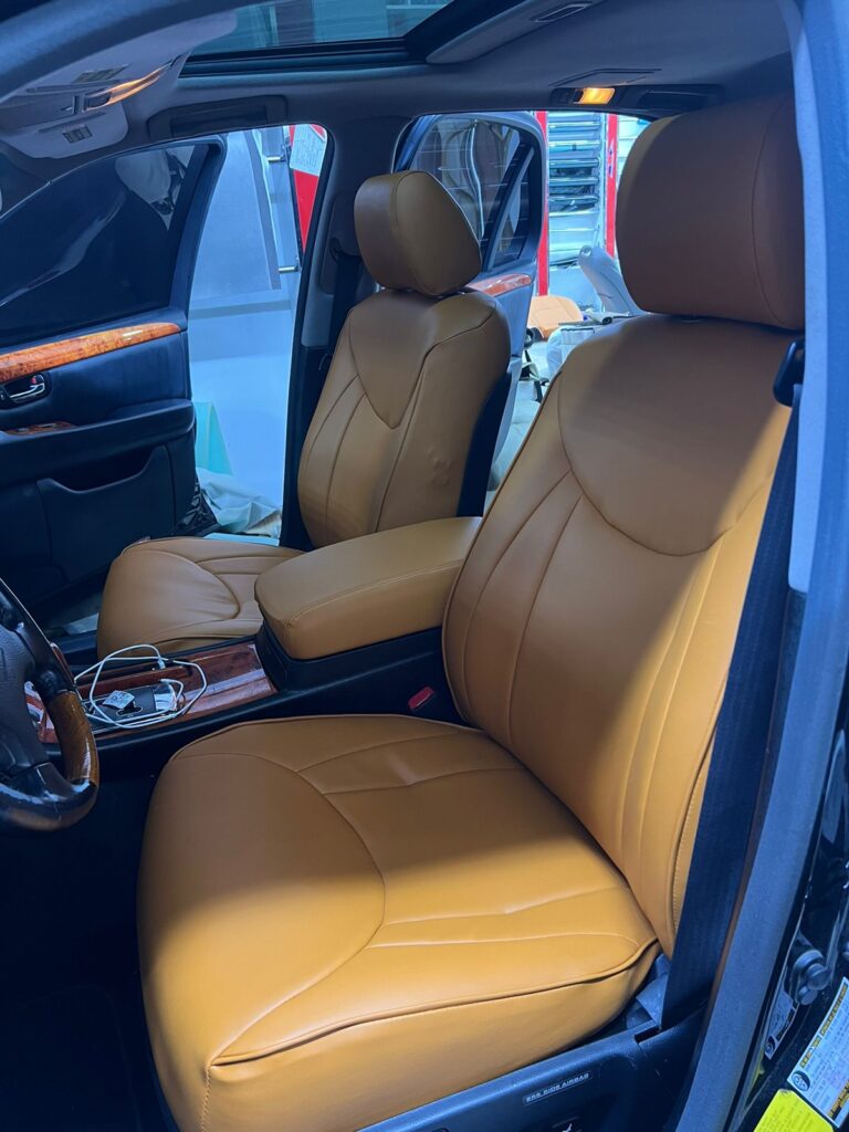 Interior view of a car featuring tan leather seats, showcasing elegant car seat upholstery and a sophisticated design.