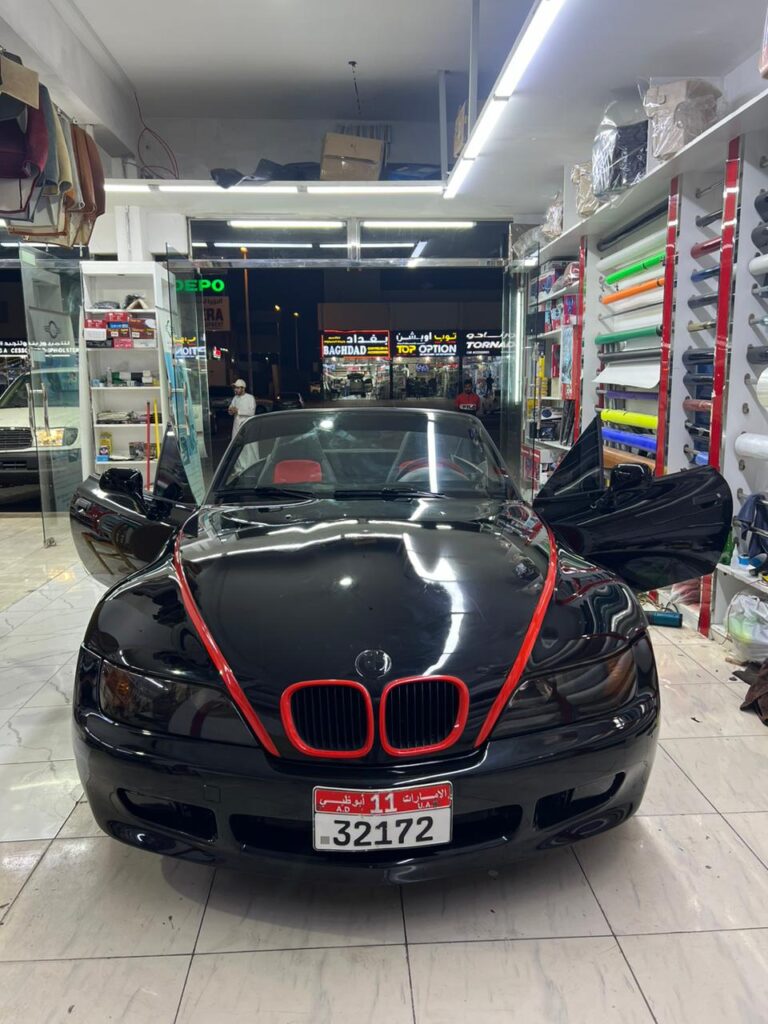 Front view of a BMW Z4 convertible with a car wrap, displayed at AlBadiya shop in Abu Dhabi.