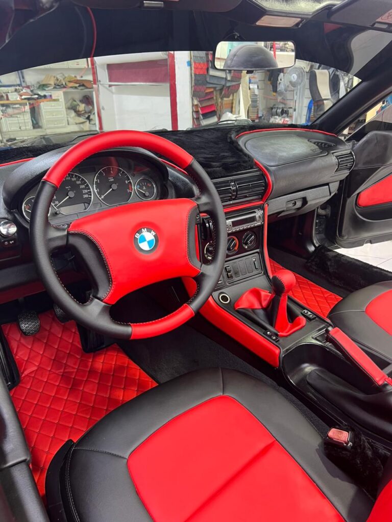 Interior view of a BMW Z3 featuring luxurious red leather upholstery, showcasing elegance and style in automotive design.