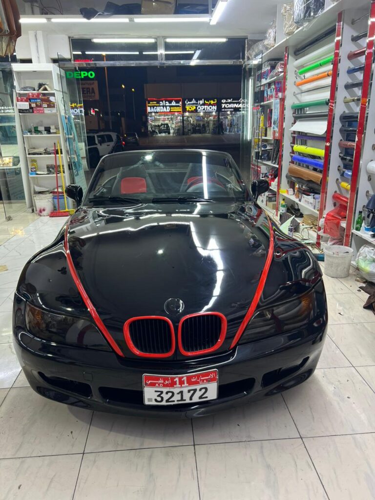 A BMW Z3 with a 2.0-liter engine and a 6-speed manual transmission, showcasing a dynamic car wrap design at AlBadiya shop in Abu Dhabi.