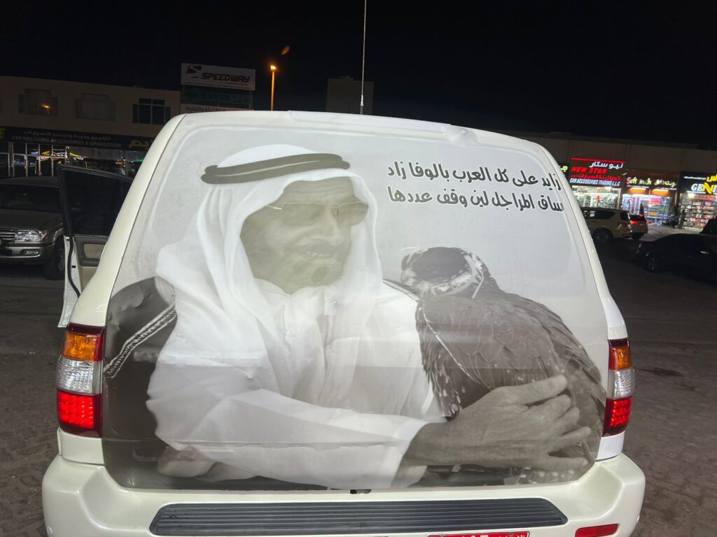 A car featuring a vibrant wrap displaying an image of an elderly man, showcasing creative vehicle customization.