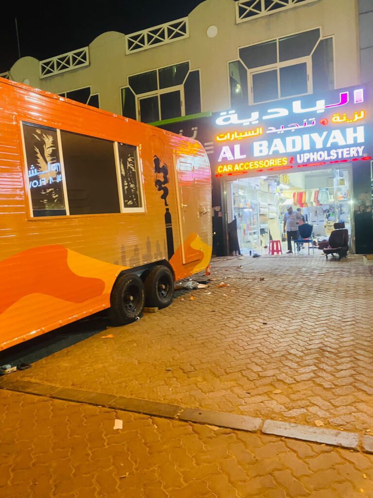 A big van's wrapping work is going on in front of the AlBadiya shop in AbuDhabi