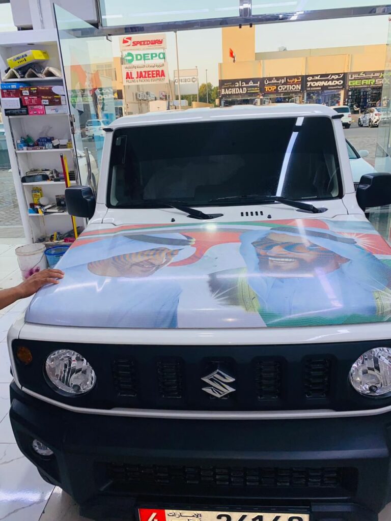 A man stands beside a car featuring a wrap of the president's image, showcasing political support and engagement.