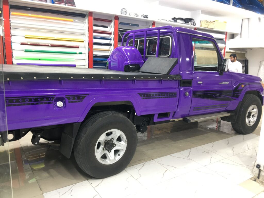 A vibrant purple pickup truck parked in AlBadiya's garage, showcasing stunning car wrapping artistry.