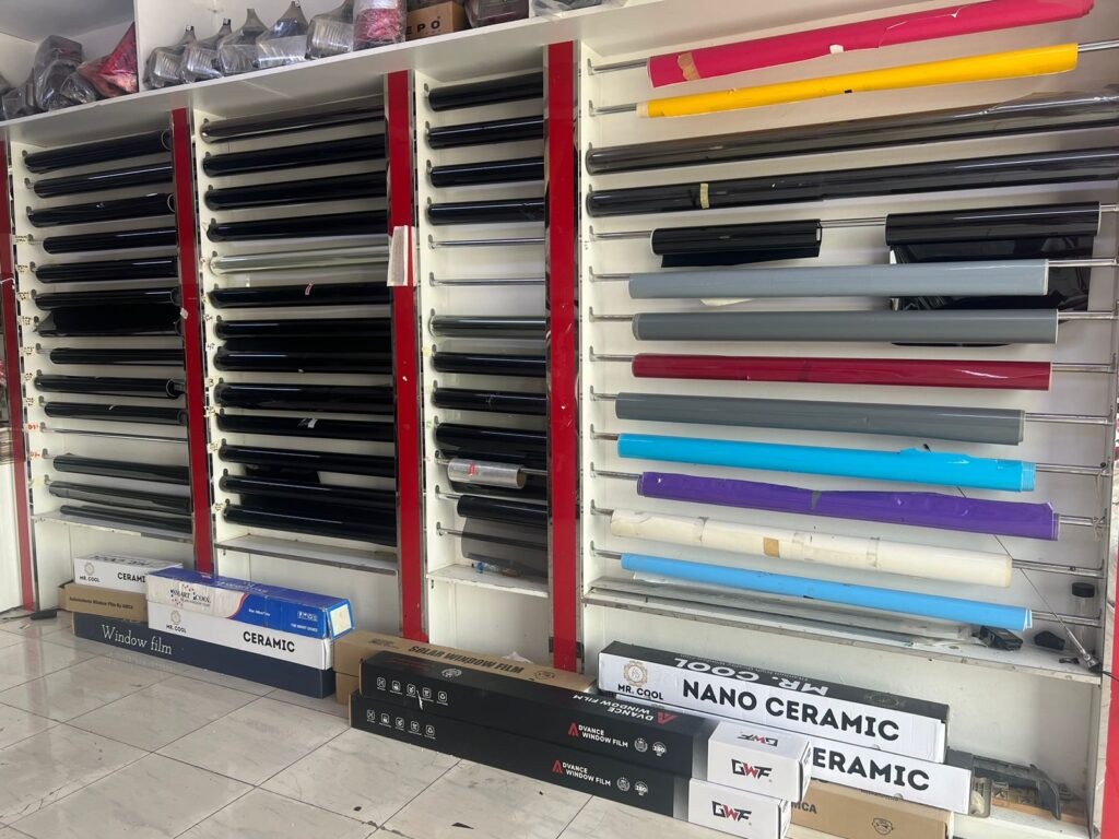 A room filled with various fabric rolls, including window tint and car wrapping paper, at AlBadiya in Musaffah, Abu Dhabi.