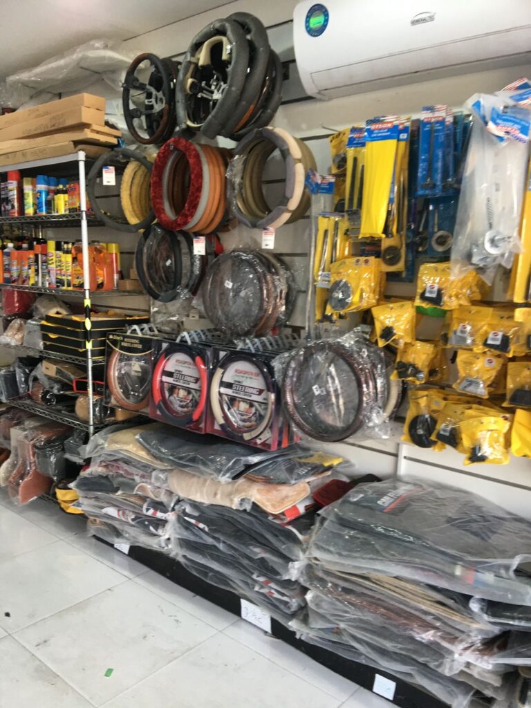 A well-stocked shop named "AlBadiya Car Accessories & Upholstery" featuring a variety of tools and equipment for automotive needs